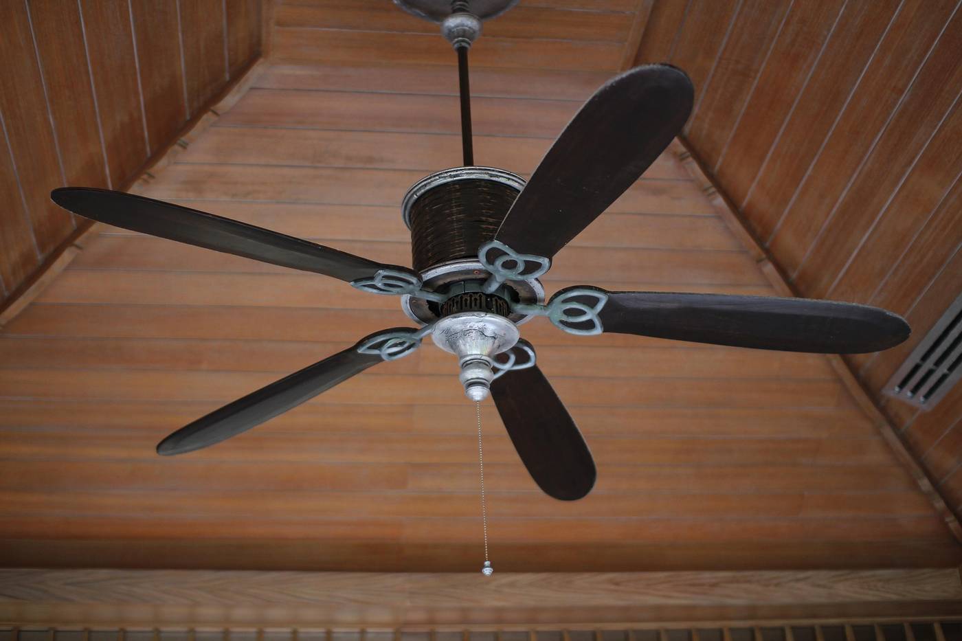 Five-blade ceiling fan mounted on a wood plank porch ceiling